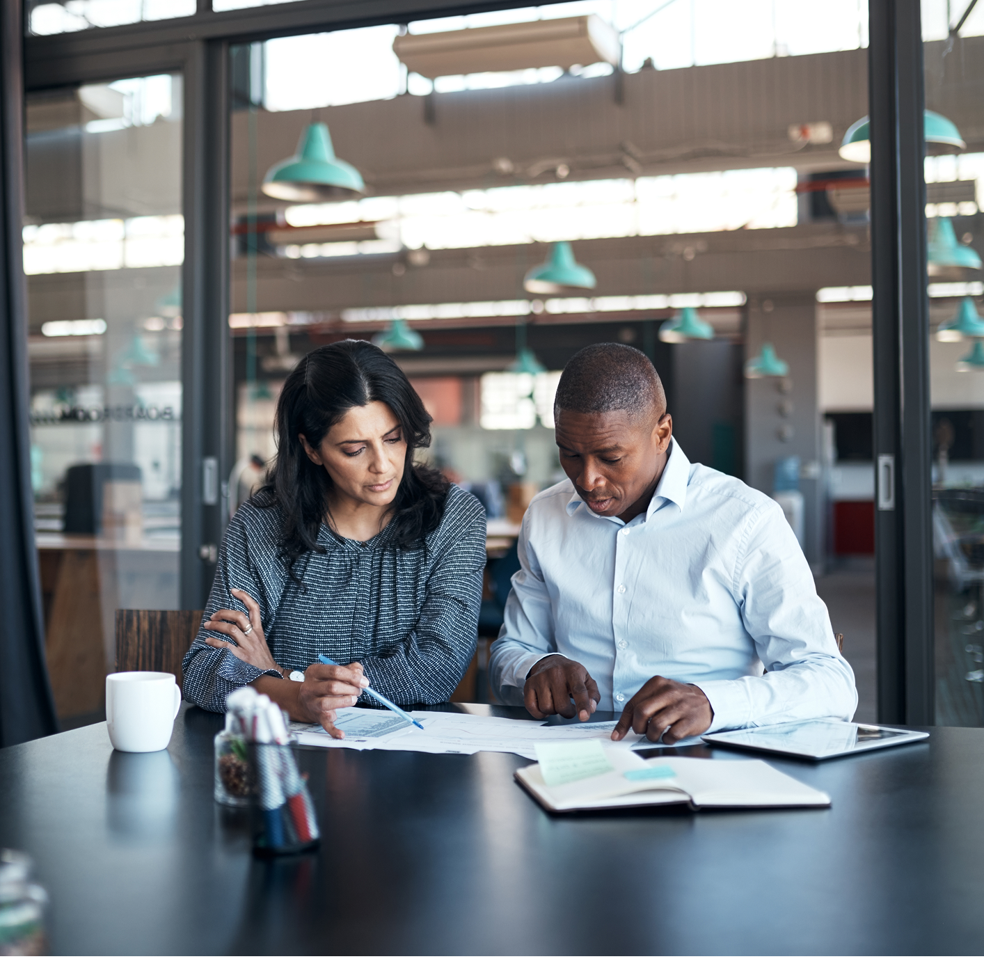Two colleagues reviewing documents in office.